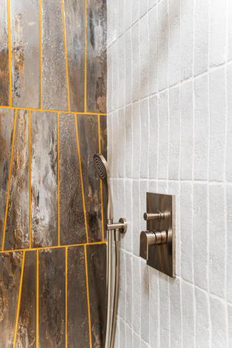 a shower in a bathroom with yellow and white tiles at La Casa del Sarto Amalfi in Amalfi
