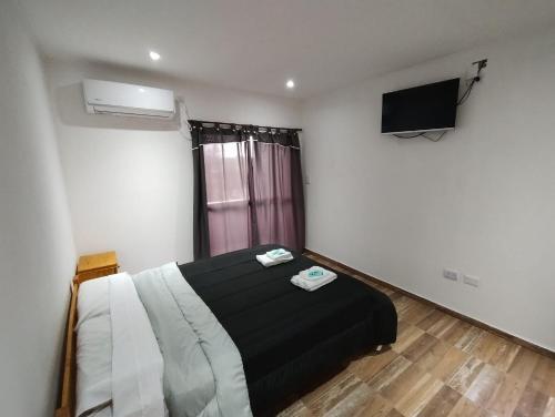1 dormitorio con 1 cama y TV de pantalla plana en El Caldén en Cañuelas