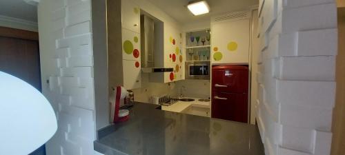 uma cozinha com um frigorífico vermelho e um lavatório em Apartamento en el Zapillo, Las Conchas II em Almeria