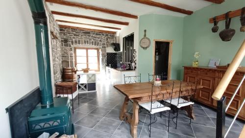 a kitchen and dining room with a wood stove at Le Carpé Diem in Saint-Privat-dʼAllier