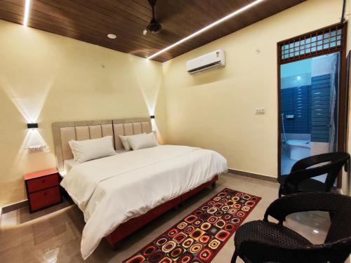 a bedroom with a bed and two chairs and a window at Sunrise Homestay Agra Near Taj Mahal in Agra