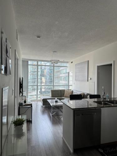 a kitchen and living room with a couch and a table at Newly updated 3BR, 2Bath in Downtown Toronto beside Union Station & Scotia Bank Arena! in Toronto