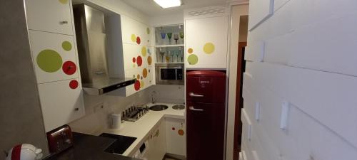 a kitchen with white cabinets and a red refrigerator at Apartamento El Zapillo II in Almería