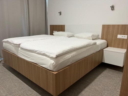 a bedroom with a large bed with white sheets at Diamant apartment pri sejmu MOS in Celje