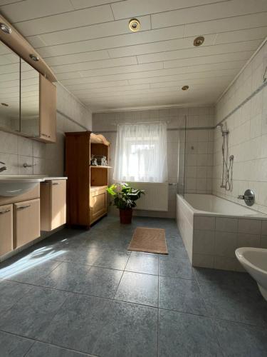 een grote badkamer met een bad en een wastafel bij Boho Home am Bach in Altmünster