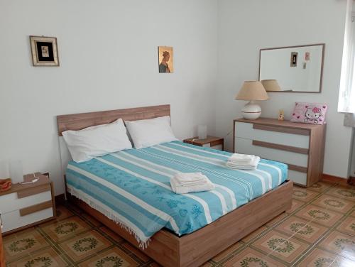 una camera con un letto con una coperta a righe blu e bianche di Casa vacanze Il Carrubo a Leporano