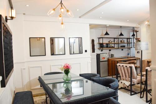 Executive Two & Three Bedroom Suites في ناكورو: غرفة معيشة مع طاولة وكراسي زجاجية