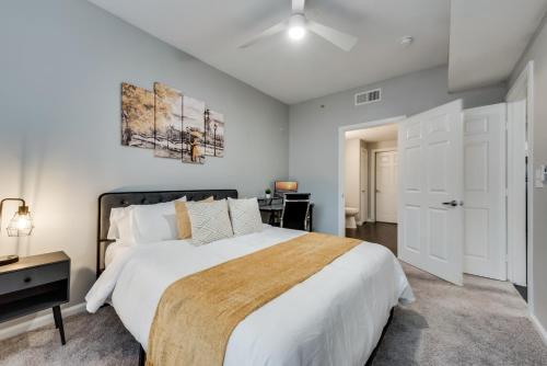 a bedroom with a large white bed and a desk at Modern 1BR Apt I Dallas City Center I Pool I Gym I Workspace I Pets in Dallas