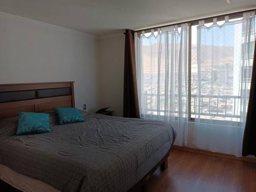 1 dormitorio con cama y ventana grande en Luminoso depto 3 dormitorios 2 baños frente al mar en Iquique