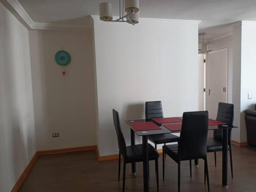 una sala da pranzo con tavolo e sedie nere di Luminoso depto 3 dormitorios 2 baños frente al mar a Iquique