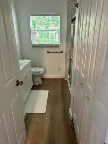 a white bathroom with a toilet and a window at Siesta Key Bay View in Siesta Key