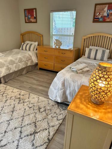 a bedroom with two beds and a table with a lamp at Siesta Key Bay View in Siesta Key