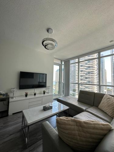 a living room with a couch and a tv at Newly updated 3BR, 2Bath in Downtown Toronto beside Union Station & Scotia Bank Arena! in Toronto