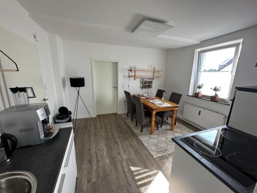 eine Küche und ein Esszimmer mit einem Tisch und Stühlen in der Unterkunft Seibels SUITES - Wohnung Ruhrgebiet in Herne