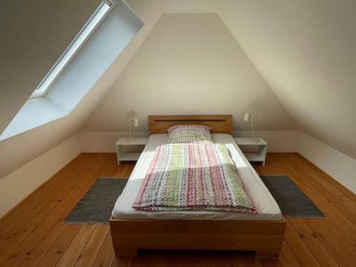 a bedroom with a bed in a attic with two tables at Bezauberndes Gästehaus auf dem Lande in Ottersberg