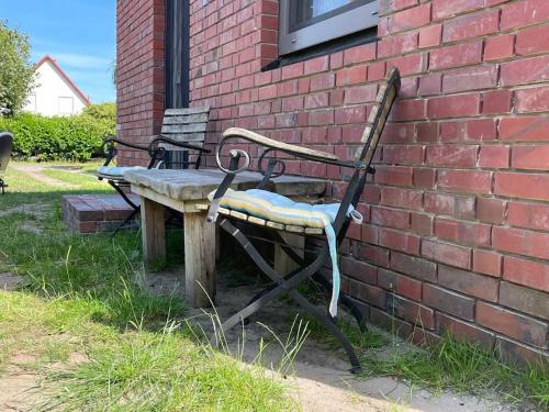 a bench sitting next to a brick wall at Bezauberndes Gästehaus auf dem Lande in Ottersberg