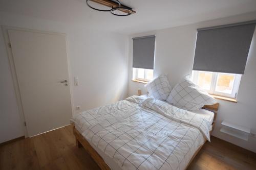 1 dormitorio con 1 cama con sábanas blancas y 2 ventanas en Concordia33 - Traumferienwohnung an der Regnitz, en Bamberg