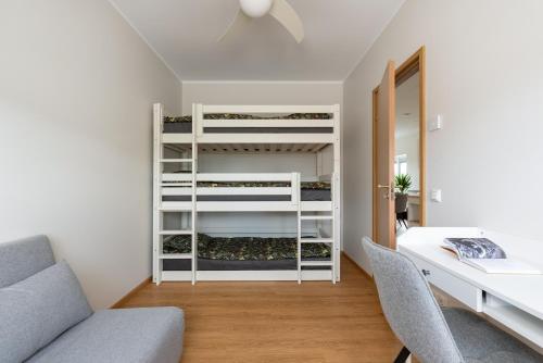 a bedroom with a bunk bed and a desk and chairs at Ridaelamuboks järve ääres in Nõo