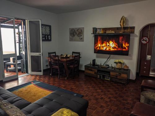 a living room with a fireplace on the wall at Casa Ascenção, vista mar Madeira in Funchal