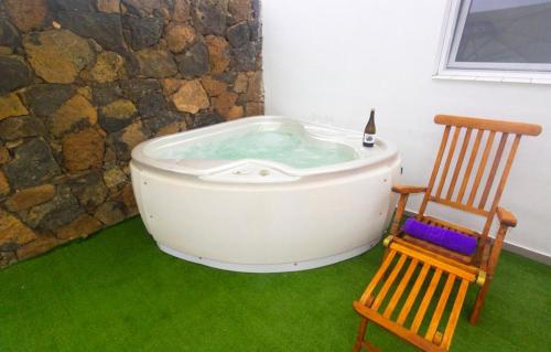 a bath tub sitting next to a wooden chair at Luxury Suite Volcan I in Mácher