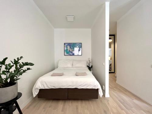 1 dormitorio con 1 cama en una habitación blanca en Cosy flat in the heart of Helsinki center, en Helsinki