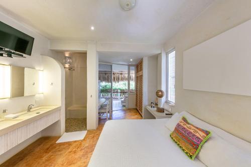 Habitación blanca con cama y baño. en Villa Maria Bed and Breakfast, en Puerto Escondido