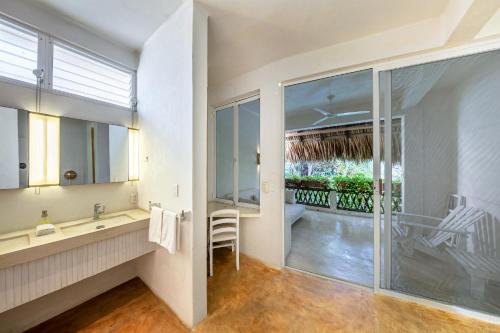 baño con lavabo y ventana grande en Villa Maria Bed and Breakfast, en Puerto Escondido