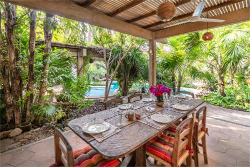 a table and chairs on a patio with a pool at Villa Maria Bed and Breakfast in Puerto Escondido