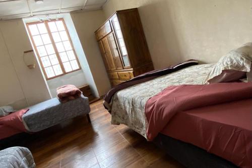 1 dormitorio con 2 camas y ventana en Mindepartamento Céntrico en Cajamarca