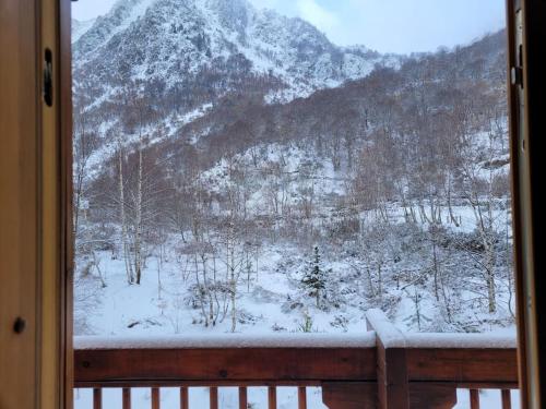 a view of a snow covered mountain from a window at Chalet bois au coeur des Pyrénées ariégeoises in Soldeu lʼHospitalet