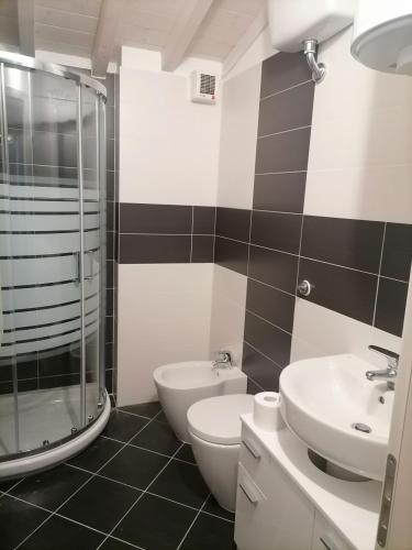 ein Bad mit einem WC, einem Waschbecken und einer Dusche in der Unterkunft Appartamento Vada in Vada