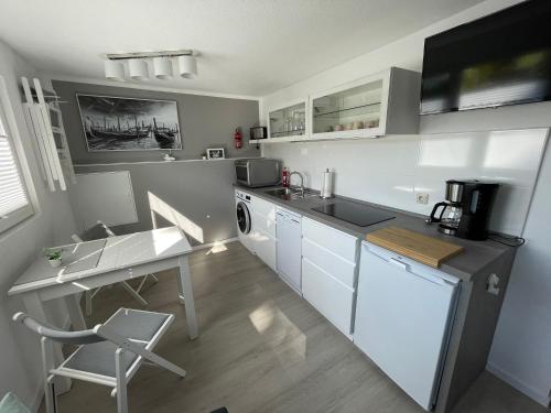 a kitchen with a sink and a table and a desk at CASALINO DI ANNA 2 in Wensickendorf