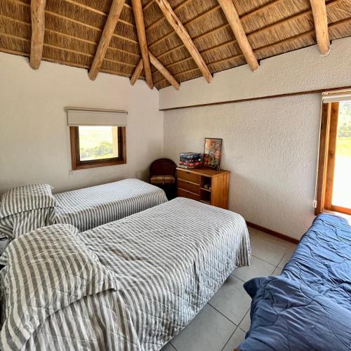 1 dormitorio con 2 camas y techo de madera en Casa de campo, en Rivera