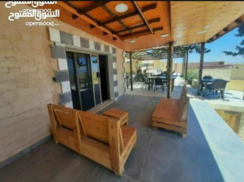 un patio con bancos, mesa y sillas en Raghad Chalet, en Jerash