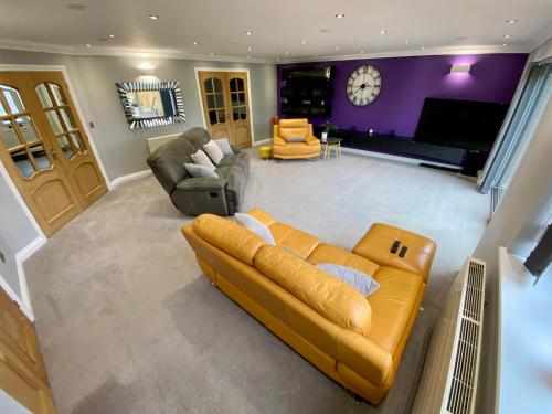 a large living room with a couch and chairs at Countryside family home in Longwell Green
