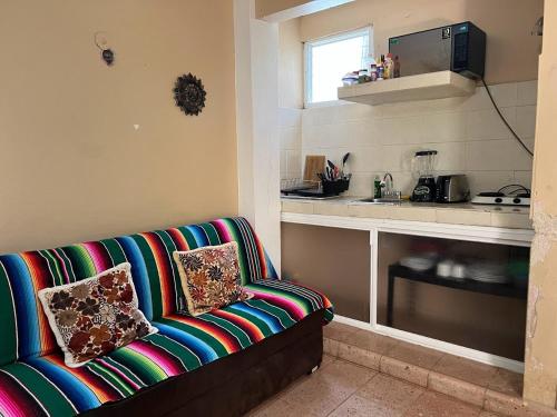 a living room with a couch and a kitchen at Villas Velarde in Cozumel