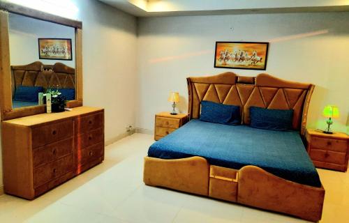 1 dormitorio con 1 cama grande y espejo grande en Anabi Apartments and Suits E11 Islamabad, en Islamabad