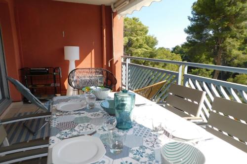 a table with plates and glasses on a balcony at Standing T2 Domaine des palmiers air-conditioned with parking and pool in Cannes