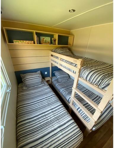 2 łóżka piętrowe w małym pokoju z: w obiekcie Mobile home proche de Europa Park w mieście Boofzheim