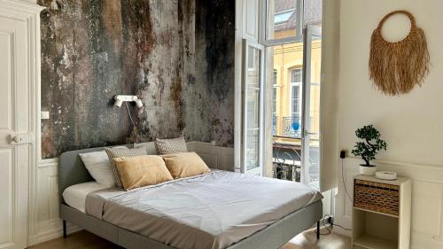 Un dormitorio con una cama en una habitación con ventana. en L'authentique, en Autun