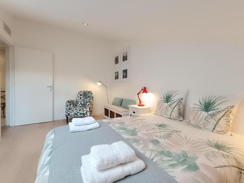 une chambre avec un grand lit avec des serviettes dessus dans l'établissement Jolly Cottage - T2 60m2 Lumineux, à Marseille