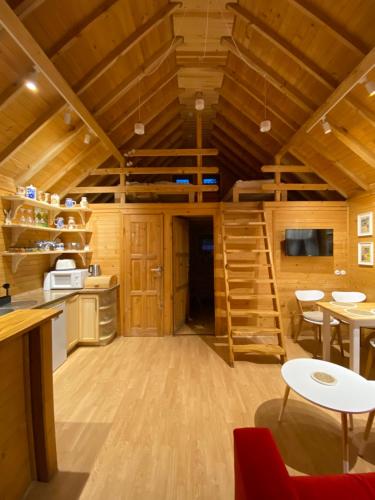 a log cabin with a kitchen and a living room at Verde Land - Drewniany domek na wsi in Osiek Mały