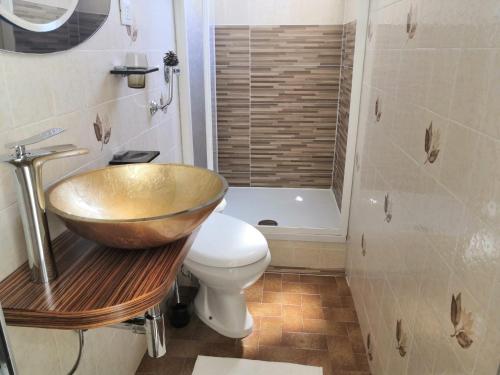 a bathroom with a bowl sink and a toilet at Apartment La Marina near the sea in Varazze