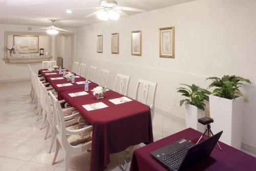 a conference room with a long table with a laptop on it at Hotel & Suites Quinta Magna in Guadalajara