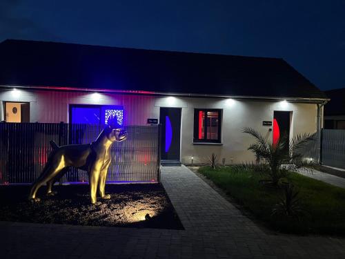 a statue of a dog in front of a house at night at Chambre Romantique avec Jacuzzi R in Gruny