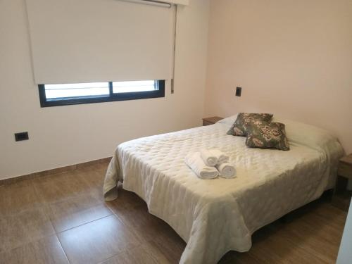 1 dormitorio con 1 cama con 2 toallas en Los Alamos en Paraná