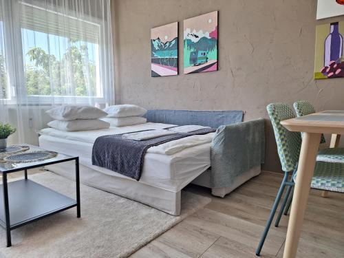a bedroom with a bed and a table and chairs at Kavics Apartman Tata in Tata