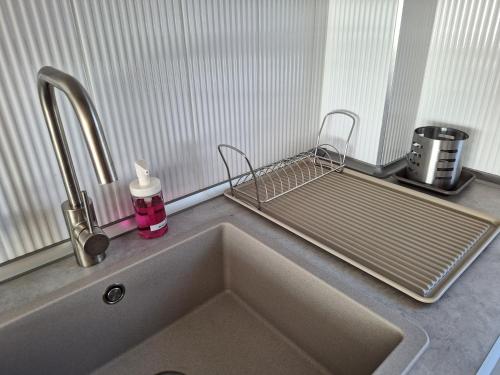 a kitchen sink with a metal rack above it at Kavics Apartman Tata in Tata