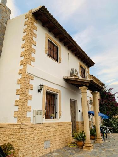 a white house with two windows and a balcony at La Venta in Purchena