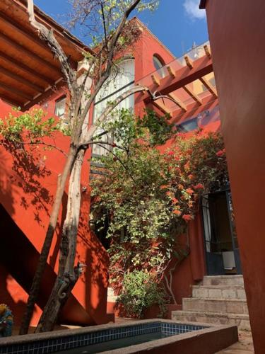 a red building with stairs and a tree next to it at Antigua Casa del Limon in Guanajuato